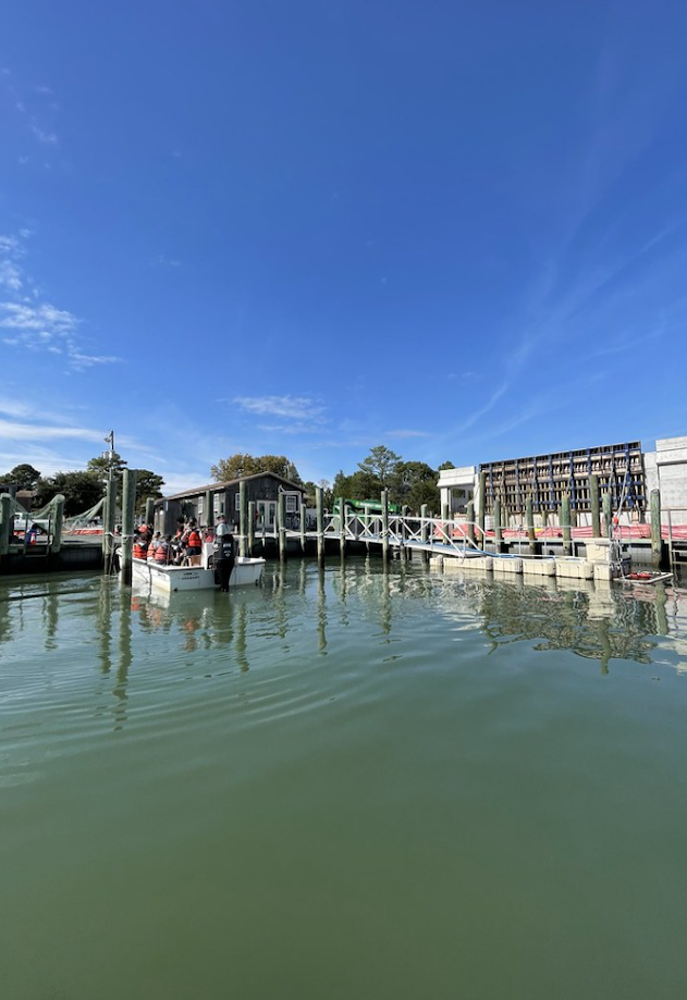 A group of students pulling their boat into a marina slip.