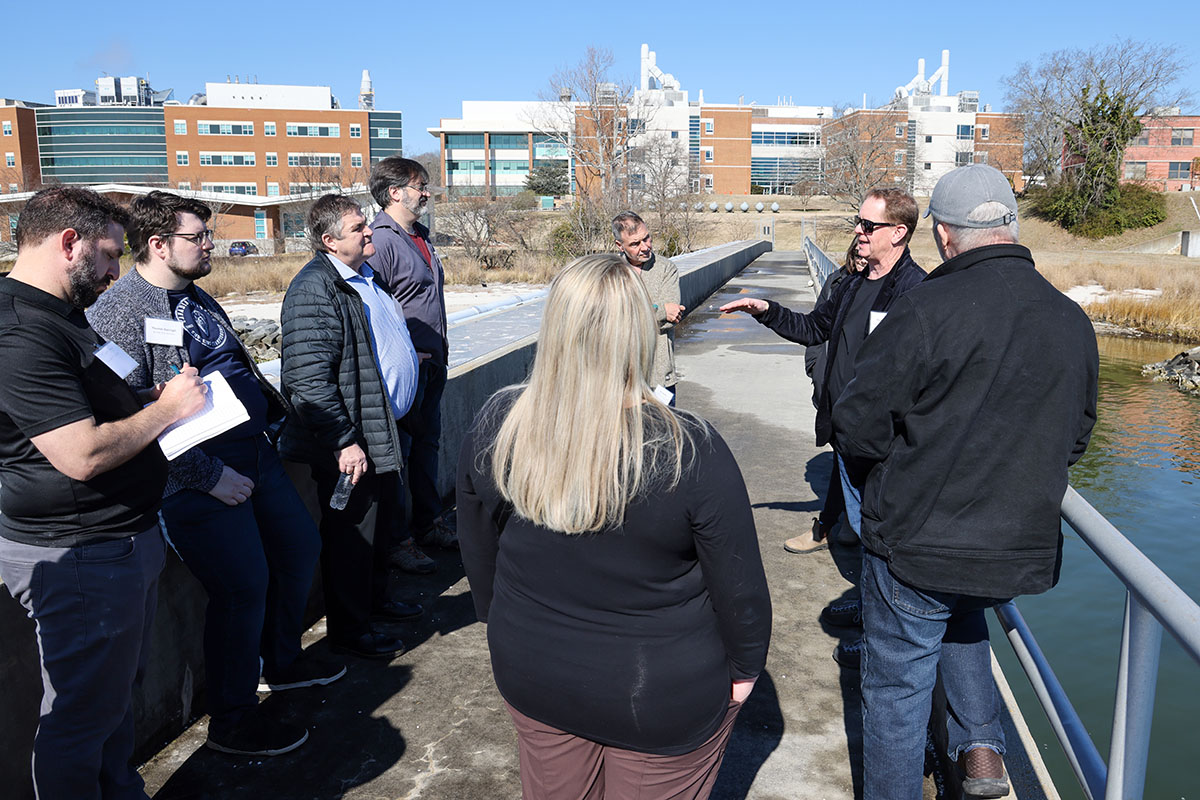 Workgroup participants gather on the pier overlooking the Batten School & VIMS research farm, which serves as a testbed for different methods of oyster aquaculture. Photo by John Wallace